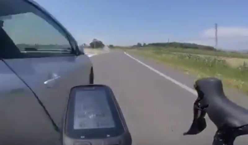 Fotograma del momento en que el conductor coge el desvío rozando al ciclista.