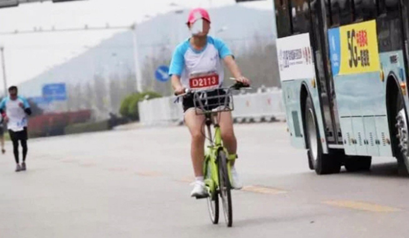 Escándalo en el maratón de Xuzhou: una corredora en bici y aficionados robando el avituallamiento